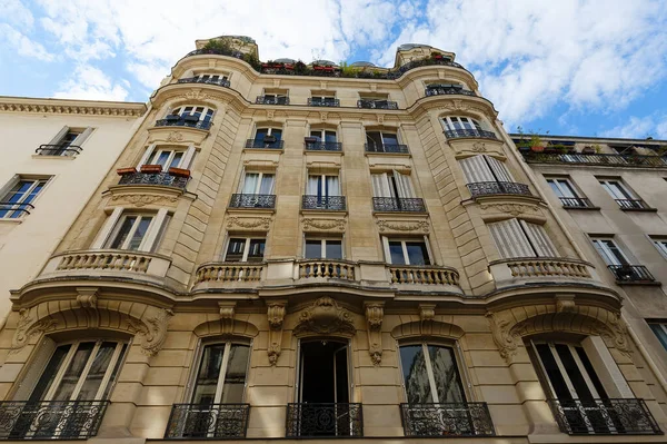 The facade of traditional French house with typical balconies and windows. Paris, France.