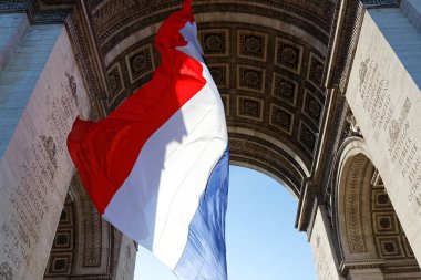 Zafer kemerinin altındaki Fransız bayrağı. Bilinmeyen askerin mezarı. Paris, Fransa. Kemer üzerine Fransızca yazı: savaşların isimleri - uygun isimler.