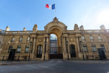 View of entrance gate of the Elysee Palace decorated with National French flags. Elysee Palace - official residence of President of French Republic since 1848.