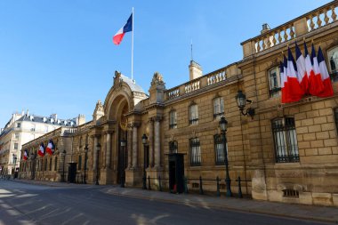 View of entrance gate of the Elysee Palace decorated with National French flags. Elysee Palace - official residence of President of French Republic since 1848.