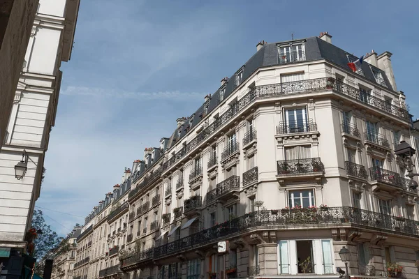 The facades of traditional French houses with typical balconies and windows. Paris, France.