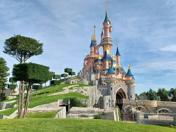 The fairytale castle in park on cloudy background.