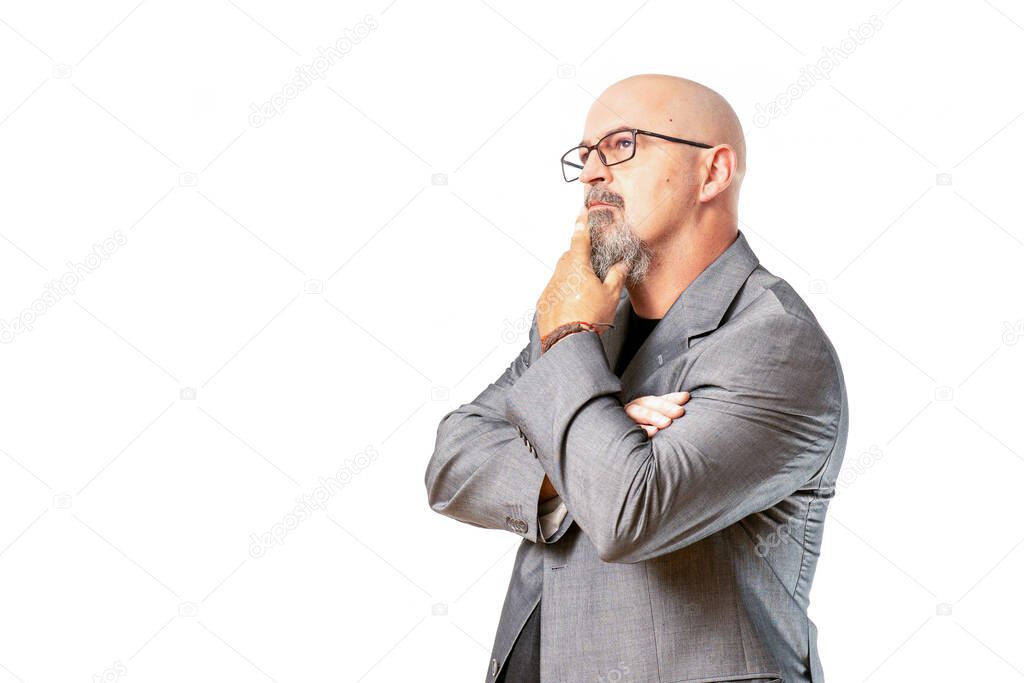 hombre atractivo calvo con traje gris de negocios haciendo posturas de asombro, foto sobre fondo blanco