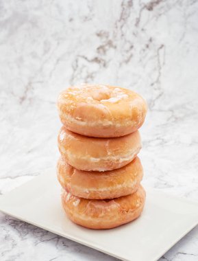 İlk plano de donuts de azucar y donuts rosas sobre una mesa blanca