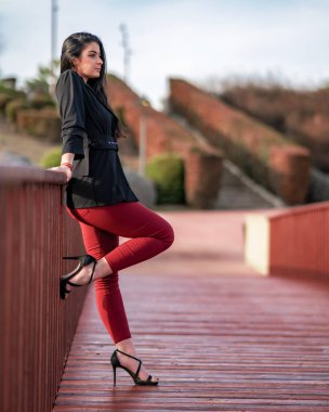 Mujer joven y atractiva posando en un parque al aire libre, pasandoselo bien una sesion de fotos