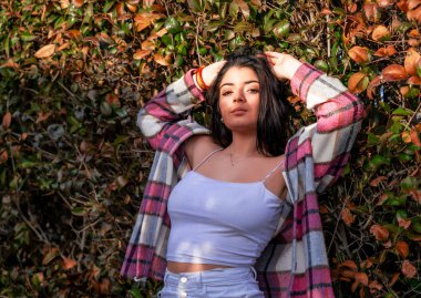 Mujer joven y atractiva posando en un parque al aire libre, pasandoselo bien una sesion de fotos