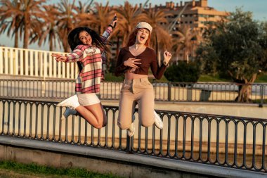pareja de mujeres jvenes pasndoselo bien en un parque al aire libre hacindose fotos con el mvil