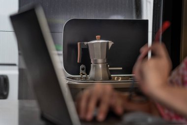 Woman teleworking on laptop from camper van while on vacation
