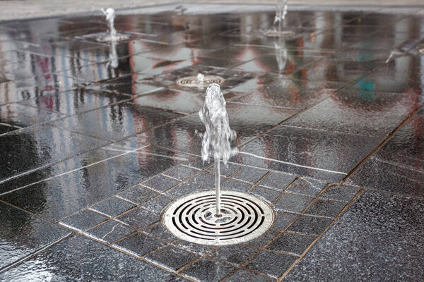 fountain on the sidewalk of the city