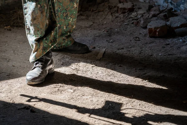 Soldado en uniforme, silueta de un arma como sombra en el suelo —  Fotos de Stock