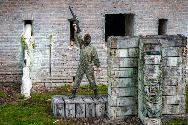 Mujer joven en acción mientras juega paintball —  Fotos de Stock