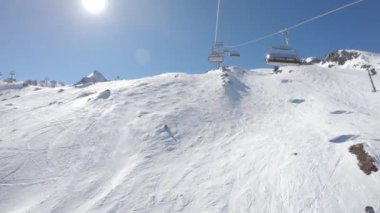 Karlı bir yamaçta teleferiğe bin.