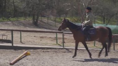 Çiftlikteki otlakta ata binerken.