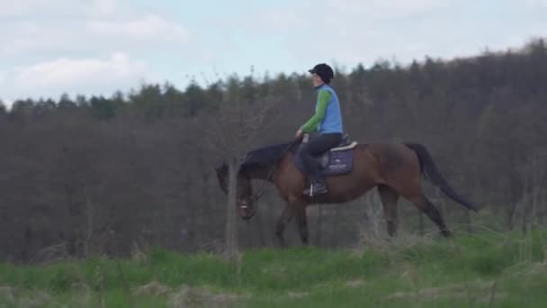 Mladá žena jezdí na koni v divočině — Stock video