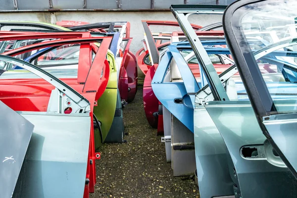 Différentes portes de voiture de couleur à un dépôt de ferraille de voiture — Photo