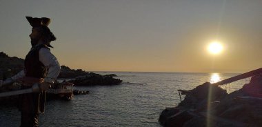 Deniz kenarındaki güzel günbatımı manzaralı korsan heykeli.