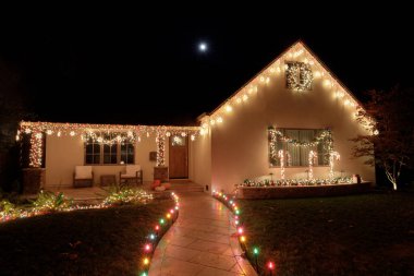 Noel ışıkları geceleri evi dolunay ile süslüyor.