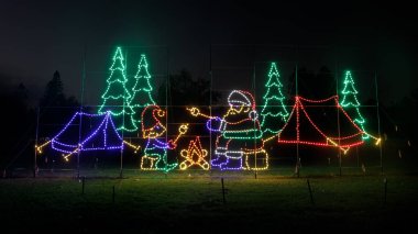 Noel Baba ailesi Los Gatos, Kaliforniya 'daki Fantasy of Lights' ta kamp ateşinde lokum kızartıyor..