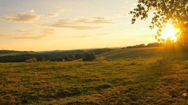 Saarland 'daki tepe manzarası. Vadi manzaralı bir çayırda gün batımı. ilginç ışık atmosferi, renkli ve güzel