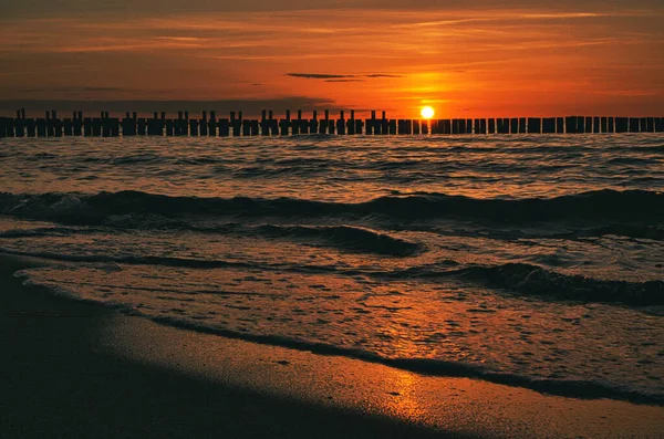 sunset in Zingst at the sea. red orange sun sets on the horizon. Seagulls circle in the sky. A beautiful light atmosphere that invites you to dream. The next vacation can come
