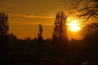 Berlin 'in varoşlarında güneş batıyor. Gökyüzü yanıyor gibi görünüyor. Romantik akşam gökyüzü.