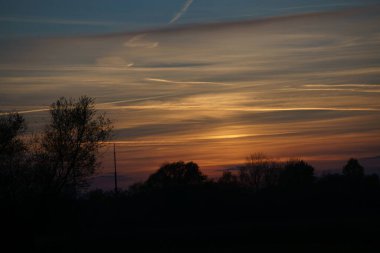 Berlin 'in varoşlarında güneş batıyor. Gökyüzü yanıyor gibi.