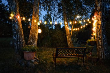 Bahçede bahçe tezgahı ve gece çitlerle gizlenmiş köşeli bir ışık demeti. Romantik hafta sonu, kutlamak ya da dinlenmek için..