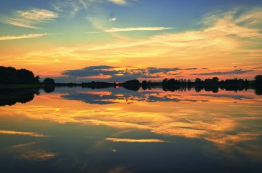 reflection of the sky in the water. gold, yellow and pink colors of the sky are reflected in the lake. Tranquility that makes you dream. Relaxation th