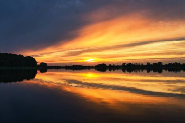 reflection of the sky in the water. gold, yellow and pink colors of the sky are reflected in the lake. Tranquility that makes you dream. Relaxation th