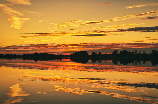 reflection of the sky in the water. gold, yellow and pink colors of the sky are reflected in the lake. Tranquility that makes you dream. Relaxation th