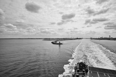 Rostock harbor exit. Looking back to Warnemuende from the ship sailing to Sweden. Cloudy sky in spring. It goes on vacation