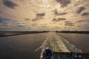 Rostock harbor exit. Looking back to Warnemuende from the ship sailing to Sweden. Cloudy sky in spring. It goes on vacation