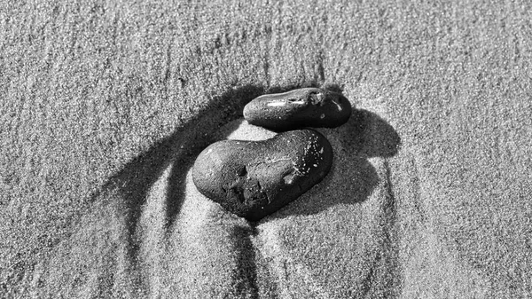 バルト海の黒と白のビーチの砂の中にハート型の石 愛の人々のためのロマンチックなシンボル 静物としての小さな看板 — ストック写真