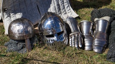 Ortaçağ ekipmanları, kask, metal eldiven, zırh. Ortaçağ gösterisinde eski zamanlara dalarsınız. Gösteri, hokkabazlar ve eğlence.
