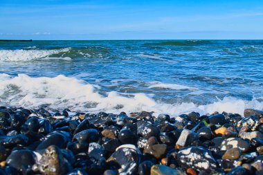 Baltık Denizi sahilinde bir sürü taş vardı. Ek olarak dalgalar plajda yuvarlanıyor. Doğa manzarası