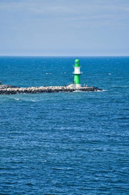 Baltık Denizi 'ndeki Rostock' taki Warnow Nehri 'nde yeşil beyaz deniz feneri. Şehrin dönüm noktası. Taşın kenarındaki dalgalar. Almanya 'dan manzara fotoğrafı