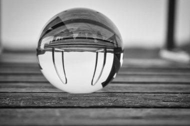 Alacakaranlıkta, İsveç gölündeki ahşap bir iskelede siyah beyaz bir top. İskandinavya 'dan doğa çekimi