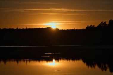 Gün batımında Smalland 'da bir İsveç gölünde yansıması var. Romantik akşam havası. Doğadaki İskandinavya manzarası