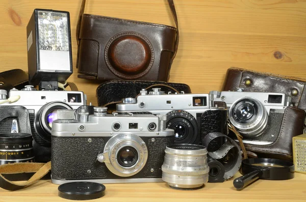 木製の背景に古いフィルムカメラとレンズ — ストック写真