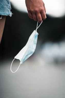 Beyaz FFP2 ve tıbbi koruyucu maske taşıyan, virüse karşı tıbbi solunum maskesi takan bir kız. Cerrahi koruyucu maske. Koronavirüsün yayılmasının önlenmesi 