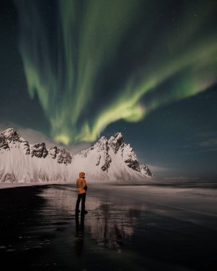 Vestrahorn Dağı, güneydoğu İzlanda 'da Aurora ile kışın sahil ve deniz kenarında karla kaplı.