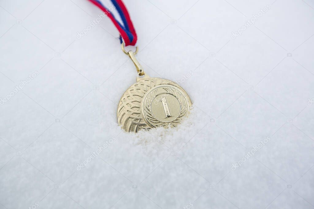 Gold medal in snow white background for winners in winter games 
