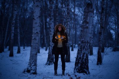 Sihirli zaman, kız donmuş ormanın ortasında duruyor karla ve elinde bir fincan çayla, Noel zamanı