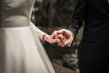  Kilisedeki genç çift evlilik töreninde yüzüklerle el ele tutuşuyor, havada aşk kokusu var.