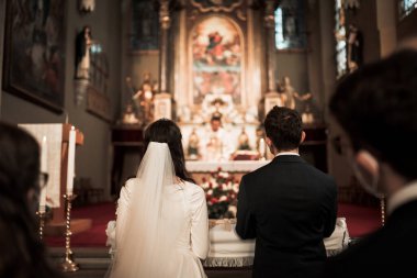 Güzel kilisedeki düğün töreninde Tanrı 'nın önünde genç bir çift.