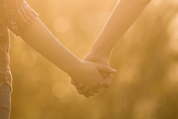 I love you! Love is in the air. Boy is holding girls hand in beautiful warm sunset light. Love between people. Relationship goals, two young people in love. Live and walking together. Summer is coming