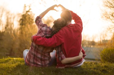 Erkek ve kız, kadın ve erkek arasında güzel bir ilişki. Havada aşk kokusu var. Birbirlerine âşıklar. Ben de seni seviyorum. İnanılmaz yaz günbatımında kalbi elleriyle gösteren iki kişi.. 