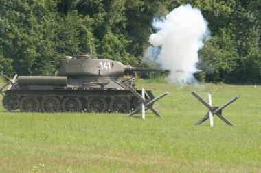 Tanklar tarlada ateş ediyor.