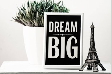  Harika bir gün olsun. Güzel bir gün için büyük, motive edici yazıtlar hayal et. Odadaki mobilyaların üzerinde çiçek, yazı ve Eyfel kulesi, şirin minimalizm, bitkiler.