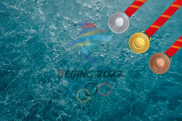 BEIJing, ÇİN - Kasım. - 25. 2021: Pekin 'deki kış olimpiyatlarının logosu altın, gümüş ve bronz madalyalarla altın madalyaların ortasında kırmızı kurdeleli, arka plan fotoğraflı kazananlar için